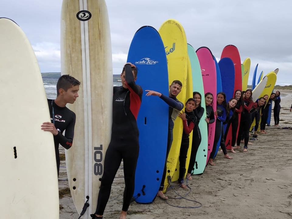 Jugendliche mit Surfbrettern am Strand