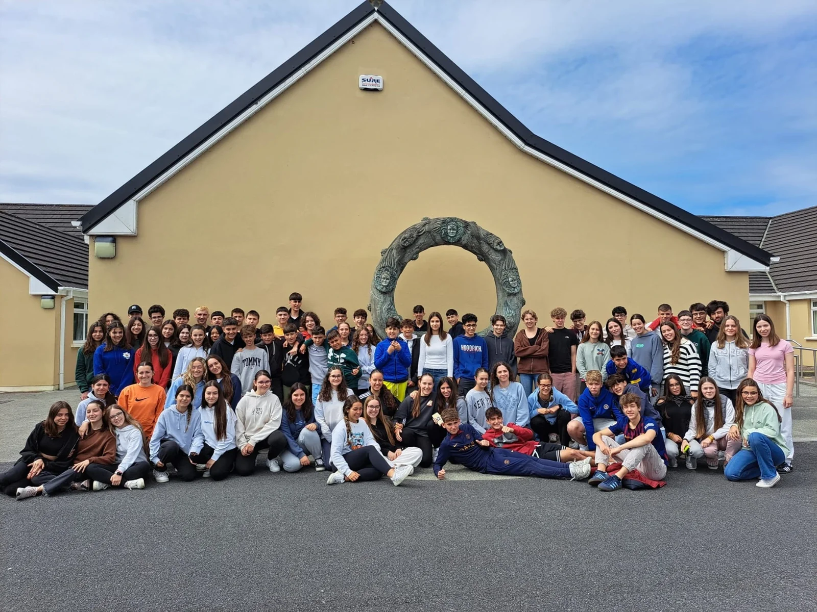 Teenage students and staff outside the school