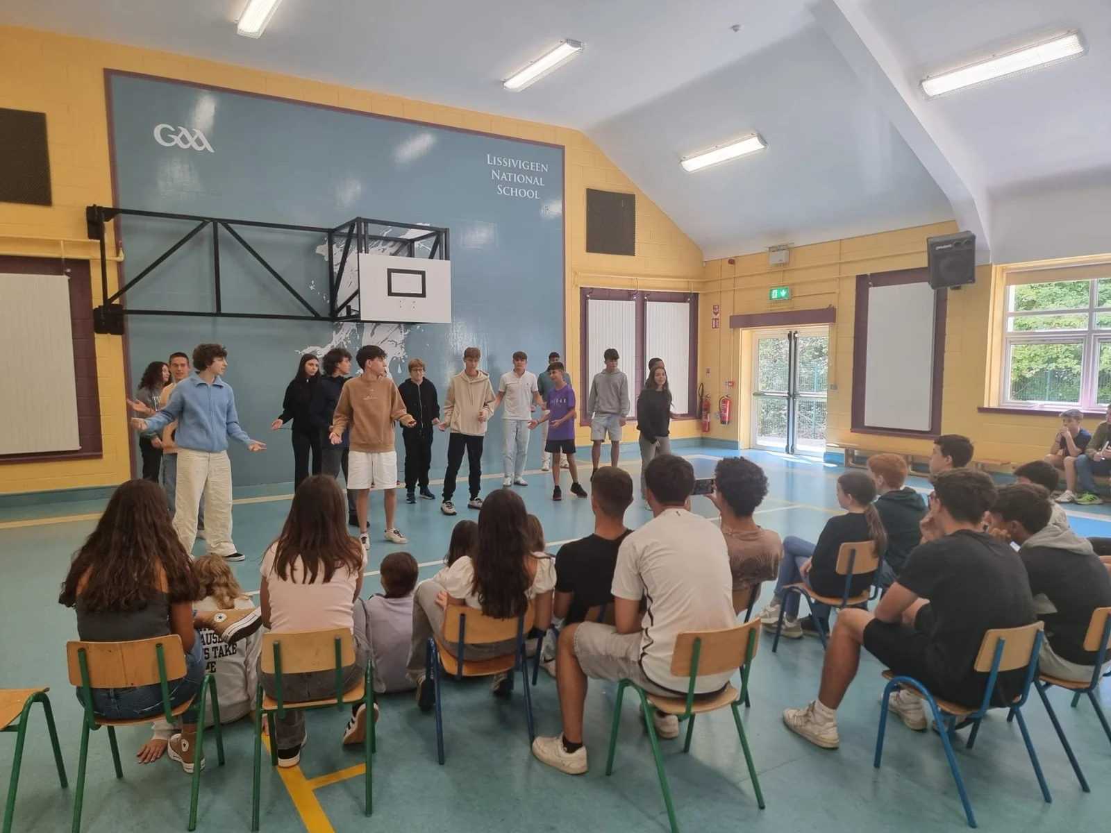 Teenage students watching a performance in the school hall