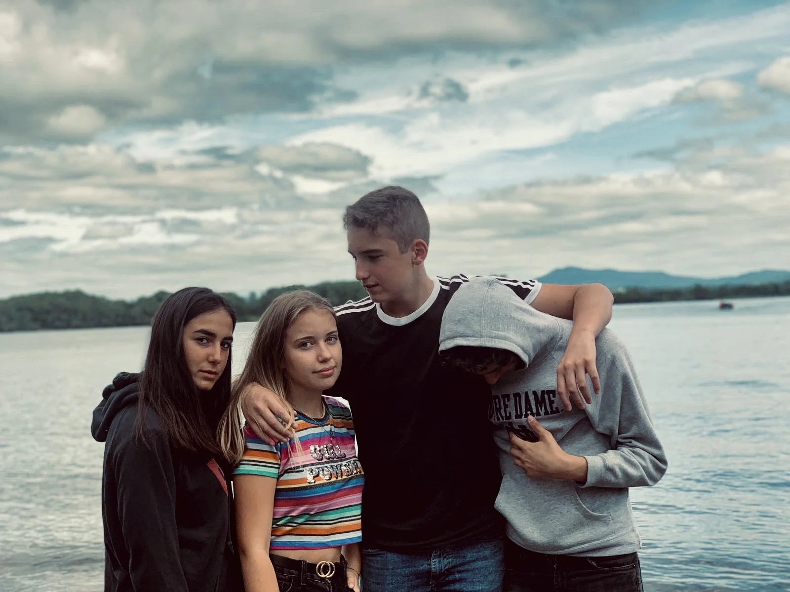 Teenage friends together beside the lake